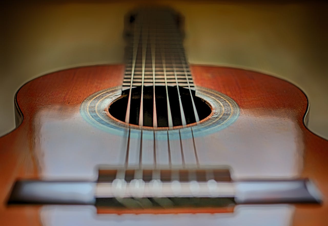 Artistic close-up of a classic acoustic guitar showing strings and soundhole.